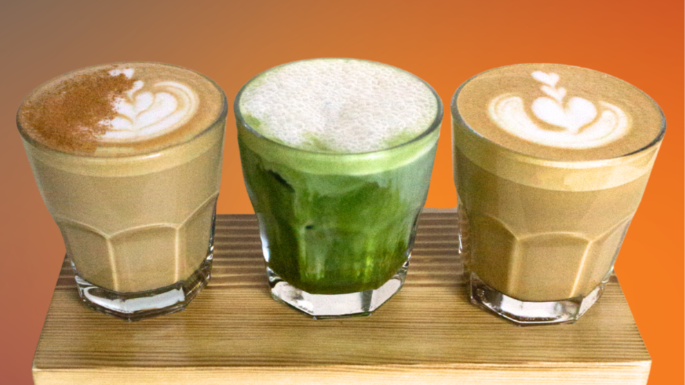 Three glasses of different beverages on a wooden stand with a gradient background